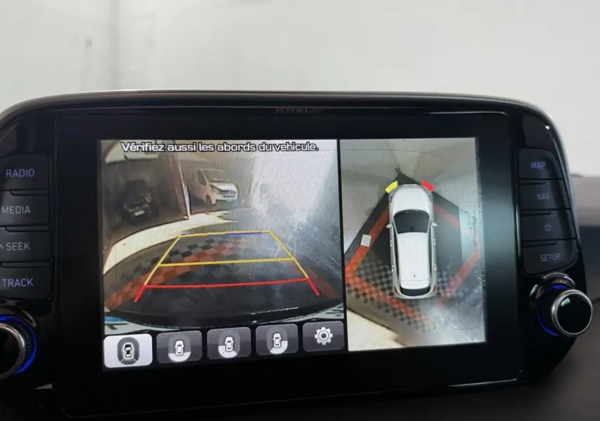 Écran tactile intérieur montrant la caméra de recul et vue à 360° du Hyundai Tucson noir en stationnement.