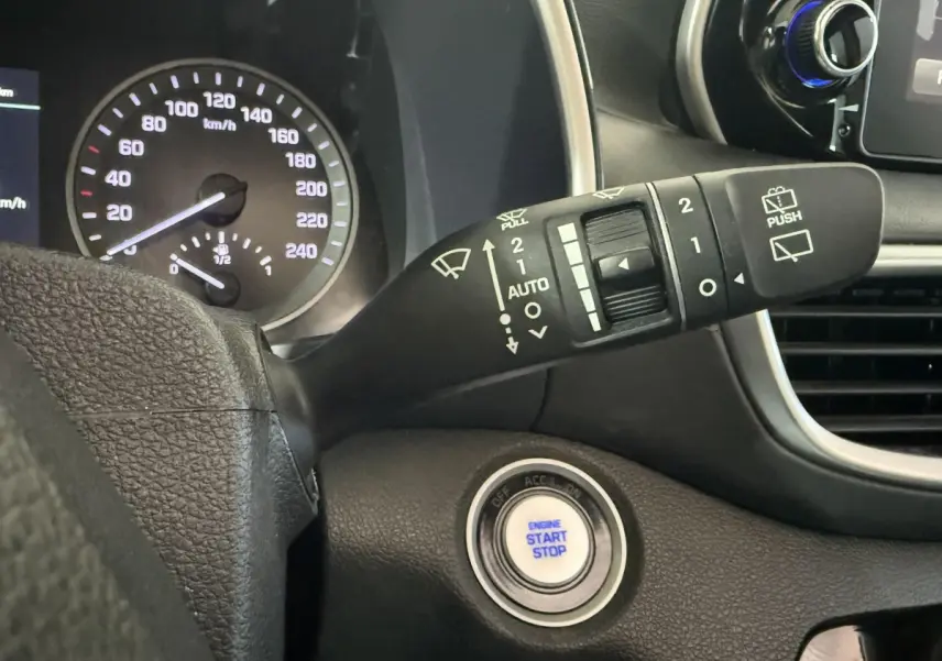Gros plan intérieur sur le bouton démarrage et le commodo d’essuie-glace du Hyundai Tucson 2019 noir.