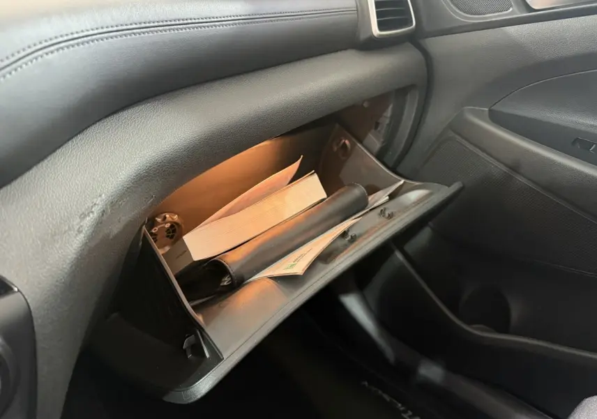 Boîte à gants ouverte éclairée dans l’habitacle noir du Hyundai Tucson 1.6 CRDI 136 Premium 2019.