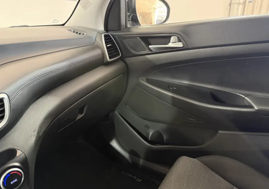 Vue intérieure côté passager du tableau de bord noir et de la porte d’une Hyundai Tucson 2019 finition Premium.