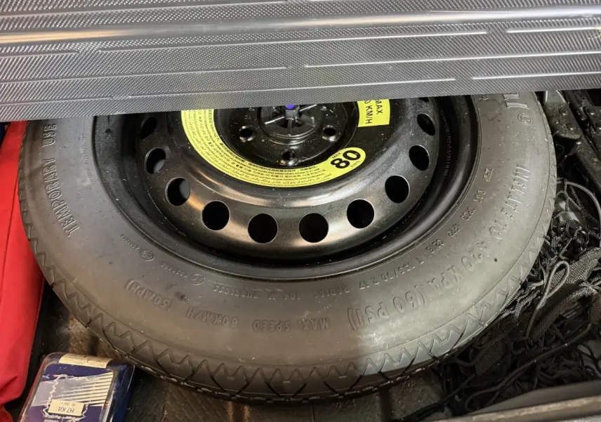 Vue rapprochée de la roue de secours noire dans le coffre du Hyundai Tucson 2019 noir, version diesel.