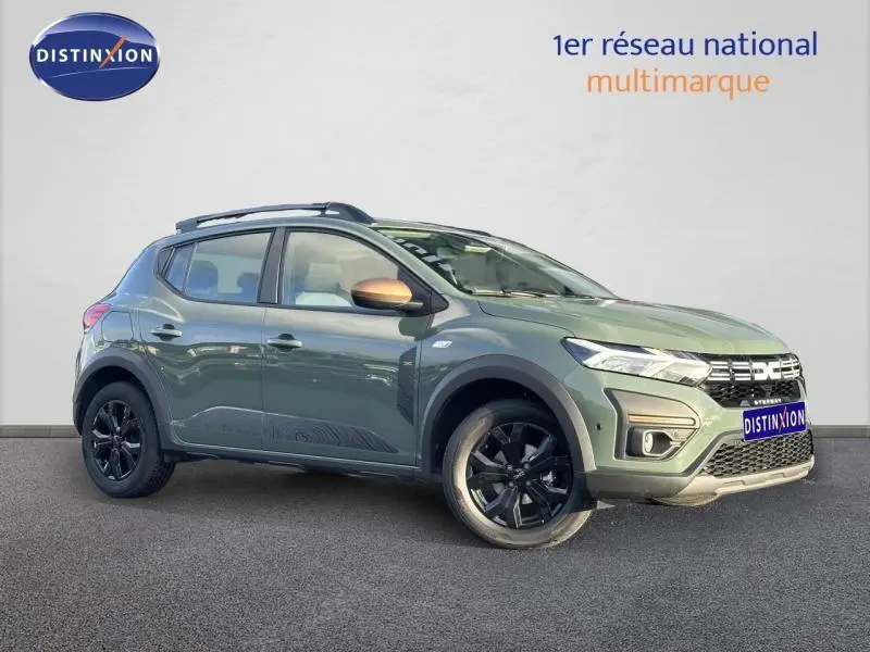 Vue 3/4 avant droit d'une Dacia Sandero Stepway 2025 blanche Glacier avec jantes noires et toit surélevé.