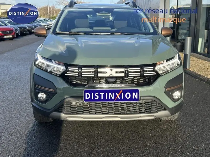 Vue avant d'un Dacia Sandero Stepway 2025 vert kaki avec calandre noire et logo central lumineux.