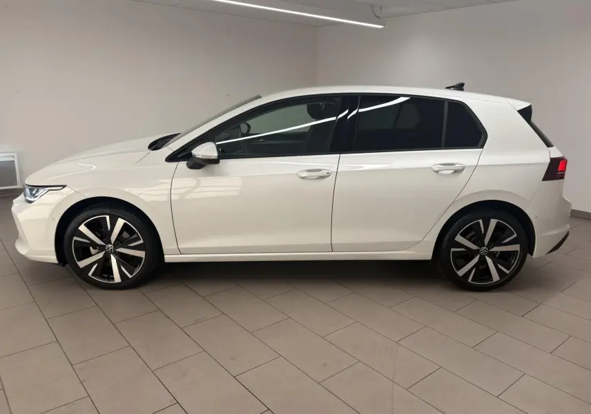Vue de profil côté gauche d'une Volkswagen Golf 1.5 eTSI 116 BVM6 VW Edition blanche nacrée avec jantes alliage 18 pouces.