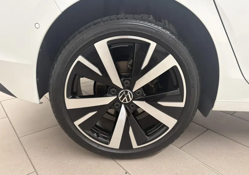 Gros plan sur la jante alliage 18'' Catania bicolore noir et argent de la Volkswagen Golf Blanc Oryx nacré, côté arrière droit.