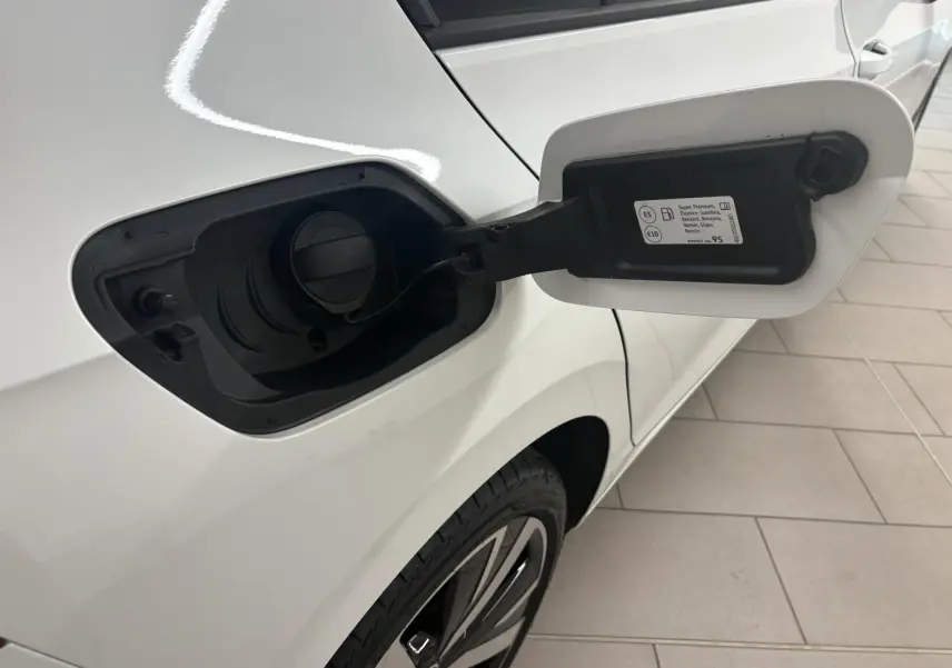 Vue rapprochée du volet de remplissage essence côté gauche d'une Volkswagen Golf blanc oryx nacré avec jante alliage 18 pouces.