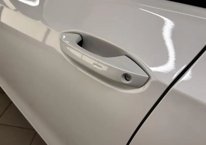 Poignée de porte côté gauche en gros plan sur Volkswagen Golf 1.5 eTSI 2025 blanc Oryx nacré.