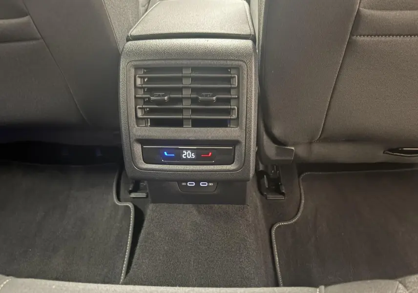 Vue rapprochée de la console arrière noire avec bouches d’aération et réglage de climatisation dans une Volkswagen Golf 2025.