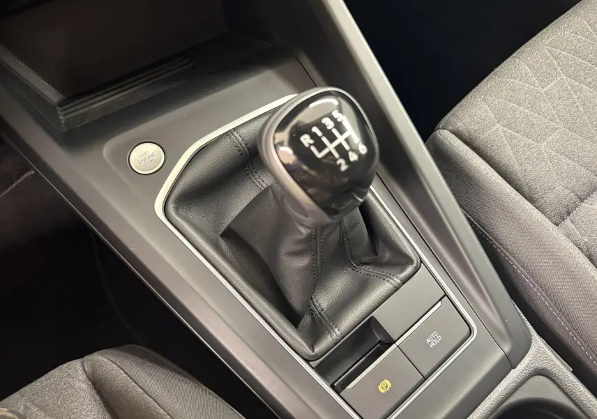 Gros plan sur la console centrale de la Volkswagen Golf 1.5 eTSI avec levier de vitesse manuelle et bouton Start/Stop.