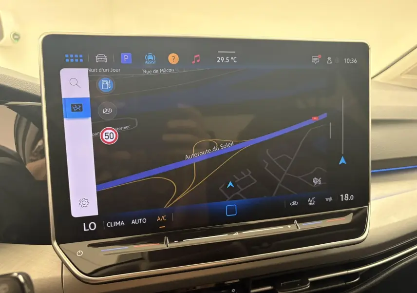 Écran tactile central du tableau de bord de la Volkswagen Golf 1.5 eTSI 2025 affichant la navigation avec carte et température intérieure.