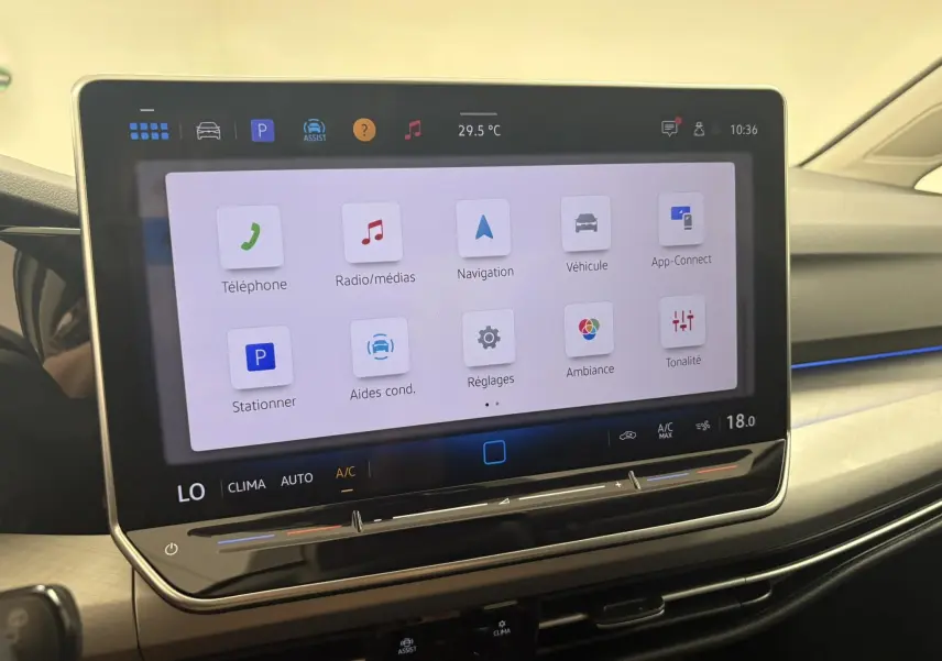 Écran tactile central de la Volkswagen Golf 1.5 eTSI 2025, affichant le menu principal avec commandes climatisation intégrées.