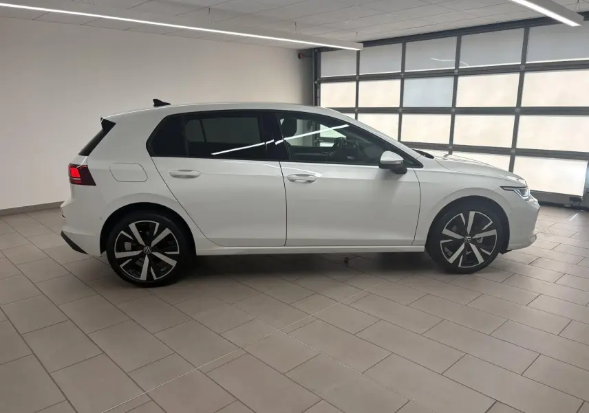 Vue de profil droit d'une Volkswagen Golf 1.5 eTSI 116 BVM6 VW Edition blanche nacrée avec jantes alliage 18 pouces Catania.