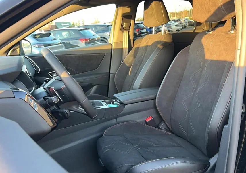 Intérieur côté conducteur du DS7 noir, montrant sièges en alcantara avec surpiqûres et accoudoir central.