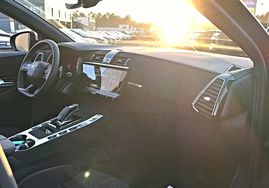 Intérieur du DS7 1.5 BlueHDi 130 noir, vue côté conducteur avec tableau de bord et écran tactile au soleil couchant.