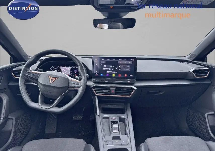Vue frontale de l'habitacle du CUPRA LEON ST 2024, tableau de bord moderne avec écran tactile et volant multifonction.