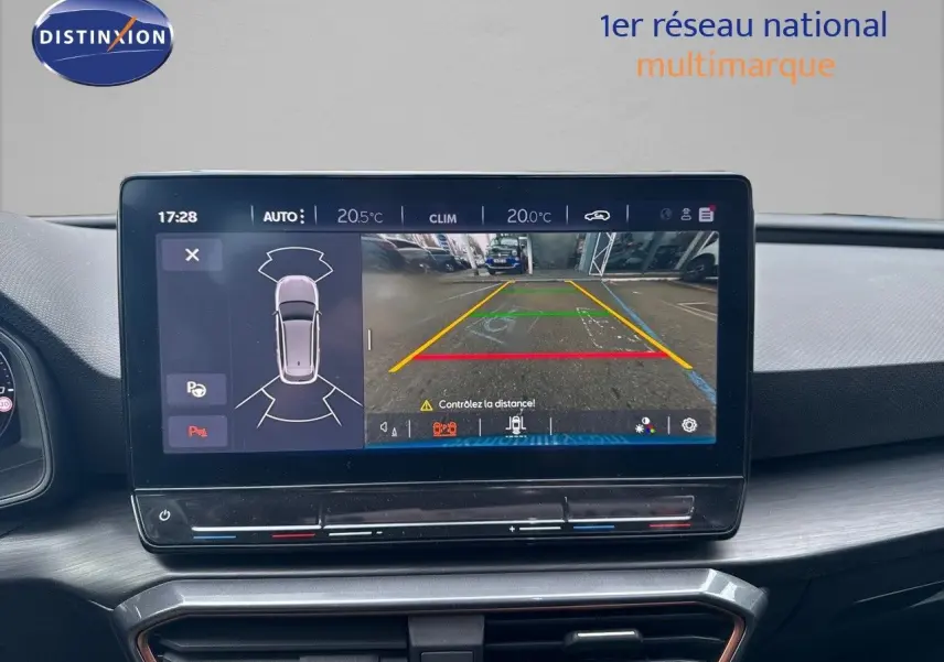 Écran central du tableau de bord de la CUPRA LEON ST gris magnétique montrant la caméra de recul et les capteurs de stationnement.