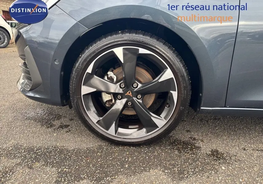 Gros plan sur la roue avant gauche d'une CUPRA LEON ST gris magnétique avec jante bi-ton distinctive.