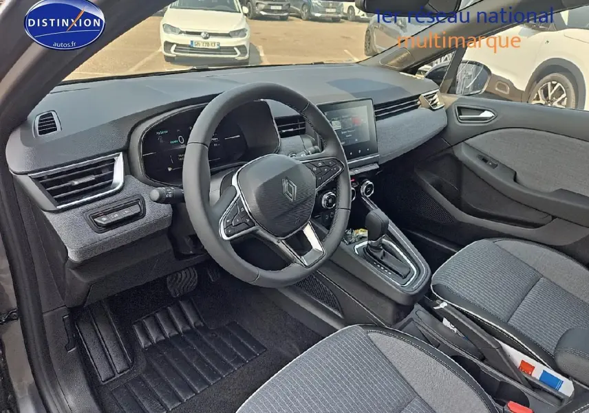 Intérieur de la Renault Clio V gris schiste, vue côté conducteur, volant multifonction et écran tactile central visibles.