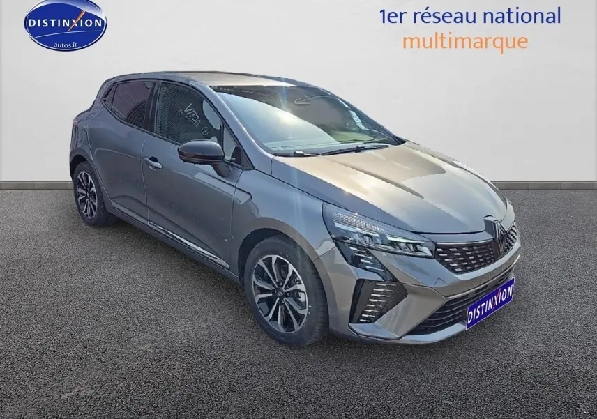 Renault Clio V gris schiste en 3/4 avant droit, avec calandre chromée et jantes alliage distinctives.