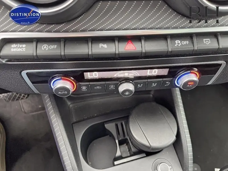 Vue rapprochée de la console centrale de l'Audi Q2 2018, avec commandes climatisation et boutons fonctionnels visibles.