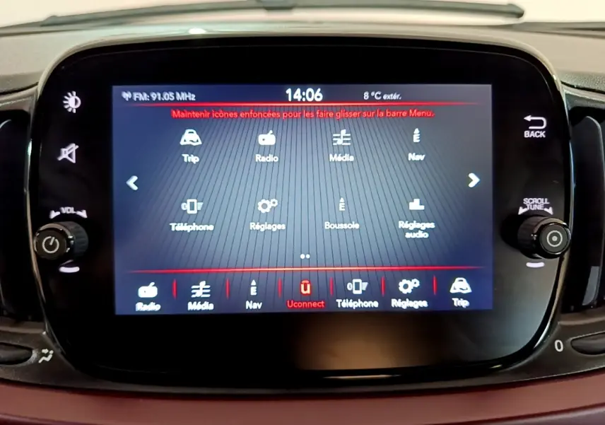 Écran tactile central du tableau de bord de la Fiat 500 rouge, affichant le menu multimédia et réglages.