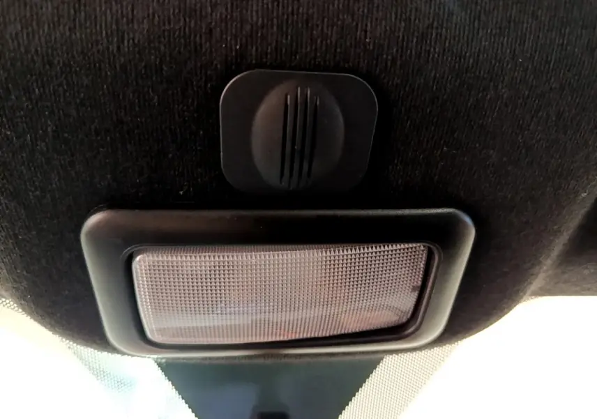 Gros plan sur la lumière intérieure et le micro de la FIAT 500 rouge, vue du plafond vers l’avant.