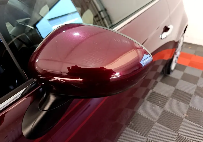 Gros plan sur le rétroviseur côté gauche rouge brillant d'une FIAT 500 1.0 70ch BSG Star, vue partielle du flanc.