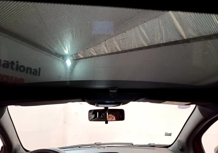 Vue intérieure avant de la FIAT 500 rouge, montrant le tableau de bord et le volant multifonctions en cuir.