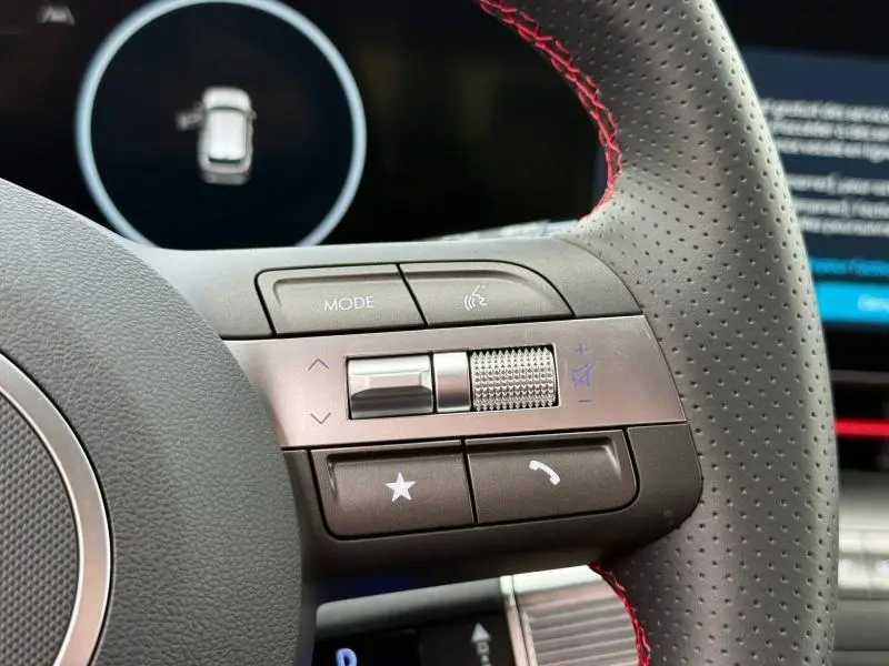 Gros plan sur les commandes multifonctions côté droit du volant cuir perforé avec surpiqûres rouges du Hyundai Kona Cyber Gray 2025.
