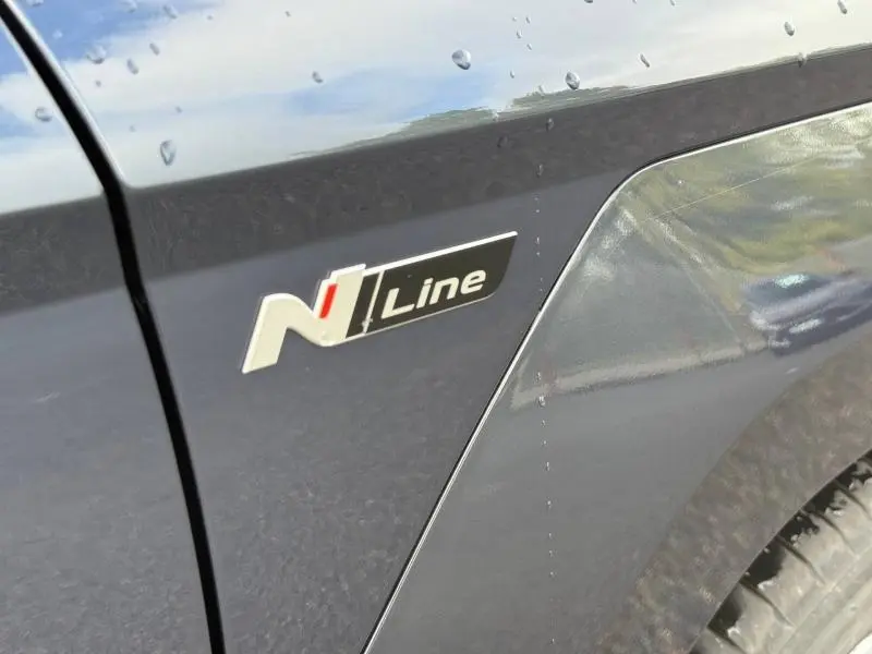 Gros plan sur l'écusson N Line sur l'aile avant droite d'une Hyundai Kona Cyber Gray métallisé.