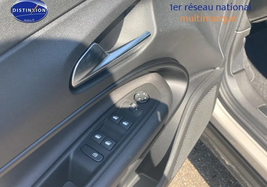 Détail de la porte côté conducteur de l'Alfa Romeo Junior 1.2 hybride 2026, avec commandes des vitres et haut-parleur intégré.