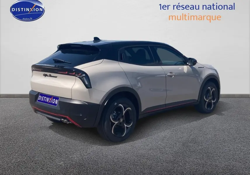 Vue 3/4 arrière droite d'une Alfa Romeo Junior 1.2 hybride ivoire et noir avec jantes alliage et toit noir.