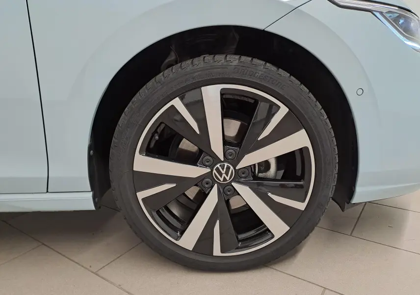 Gros plan sur la roue avant droite d’une Volkswagen Golf Bleu Glacier avec jante alliage léger 18 pouces design Catania.
