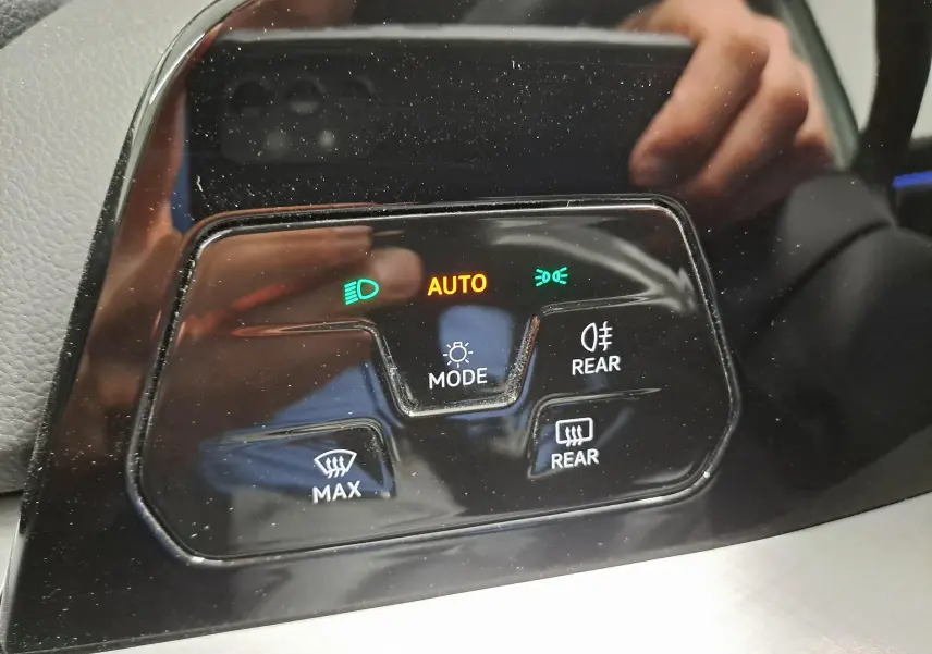 Gros plan sur les commandes d’éclairage et désembuage arrière du tableau de bord d’une Volkswagen Golf Bleu Glacier.
