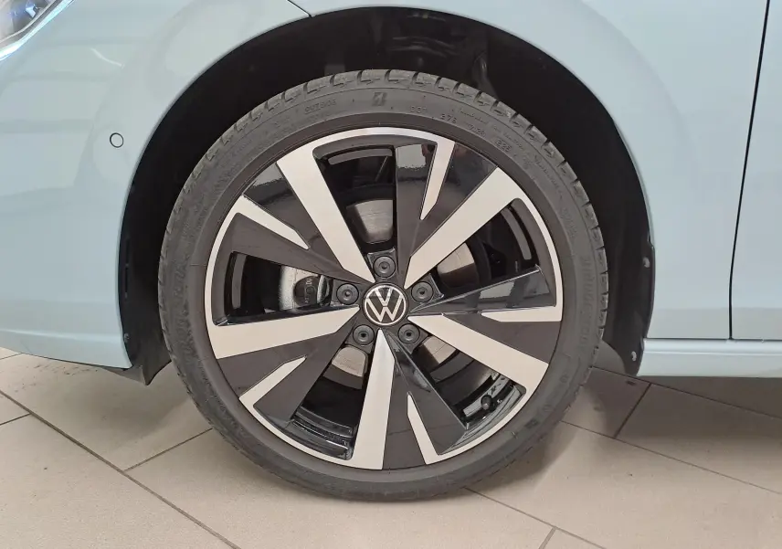 Gros plan sur la jante alliage 18'' Catania bicolore noire et argentée du côté avant droit d'une Volkswagen Golf Bleu Glacier.