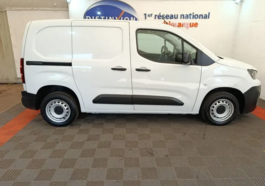 Profil droit du Peugeot Partner blanc 2022, version utilitaire avec cloison pleine et jantes acier simples.