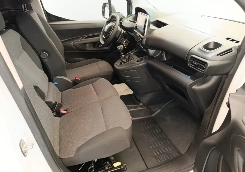 Vue intérieure côté conducteur du Peugeot Partner 2022 avec sièges gris et tableau de bord noir moderne.