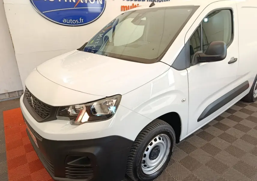Peugeot Partner blanc vu en 3/4 avant droit, avec pare-chocs noir mat et jantes acier simples.