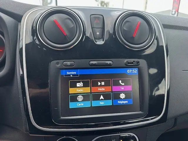 Vue rapprochée de la console centrale de la Dacia Logan MCV 2019, écran tactile avec menus colorés et commandes de climatisation.