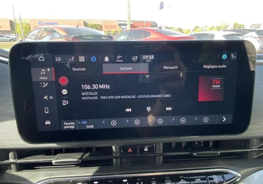 Écran tactile central du tableau de bord de la Fiat 500 Electrique noire, affichant la radio FM à 106.30 MHz.