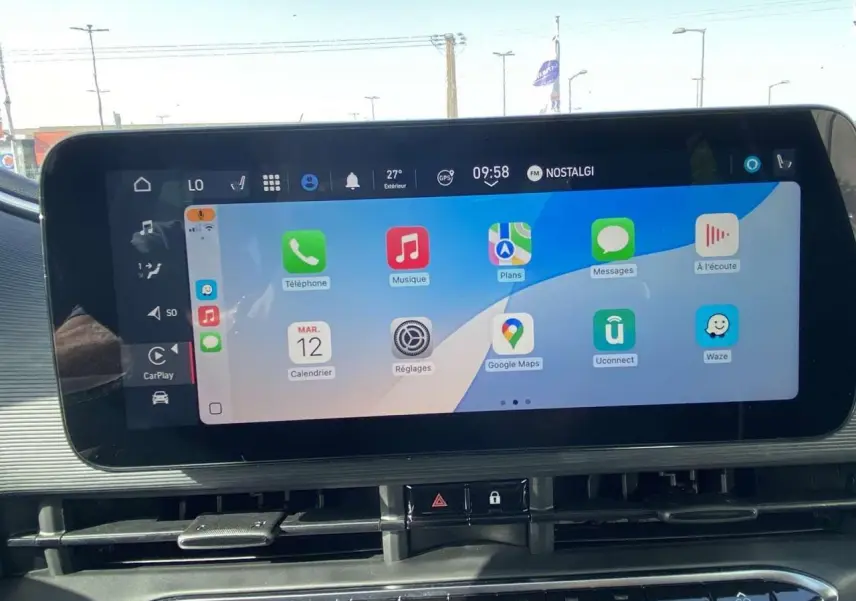 Écran tactile central affichant Apple CarPlay dans l'habitacle d'une Fiat 500 Electrique noire, vue de face.