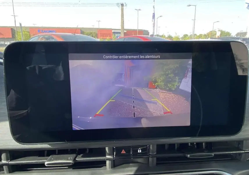 Écran central affichant la caméra de recul d'une Fiat 500 Electrique noire, vue depuis l'intérieur du véhicule.