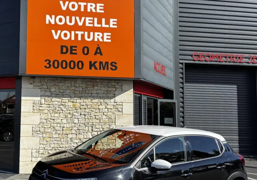 Citroën C3 PureTech 110 BVM6 Max noir avec toit blanc vue 3/4 avant, stationnée devant un panneau orange Distinxion.