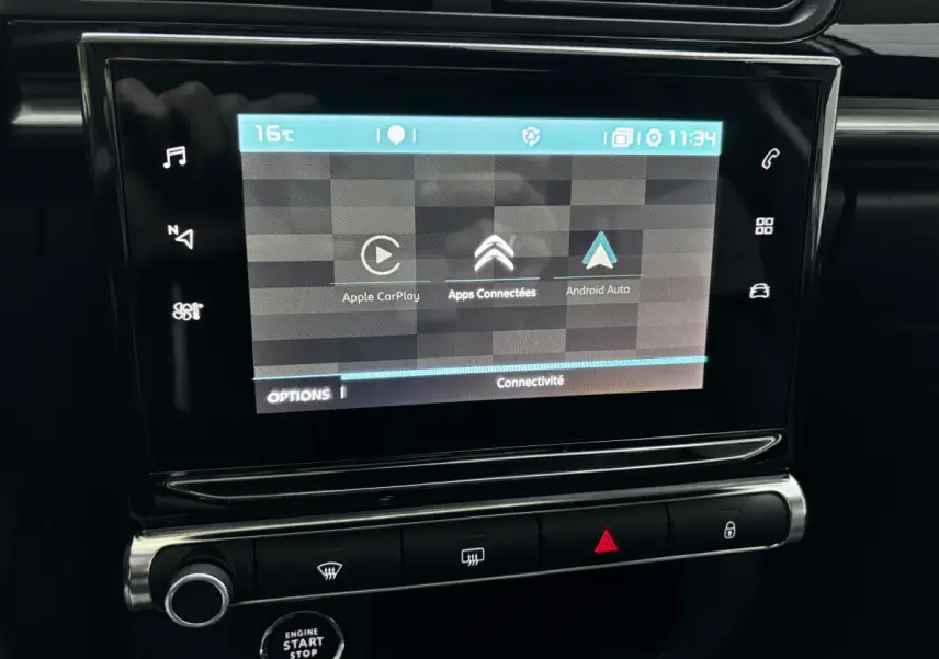 Écran tactile central affichant Apple CarPlay et Android Auto dans le tableau de bord noir d'une Citroën C3 2024.