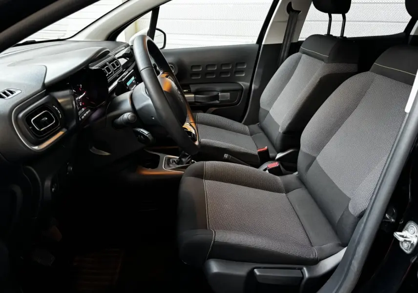 Intérieur de la Citroën C3 PureTech 110 gris clair, vue côté conducteur montrant sièges et tableau de bord moderne.