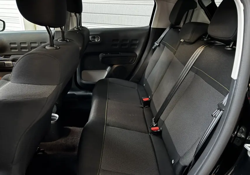 Banquette arrière noire vue côté droit dans une Citroën C3 2024, avec ceintures et appuie-têtes visibles.