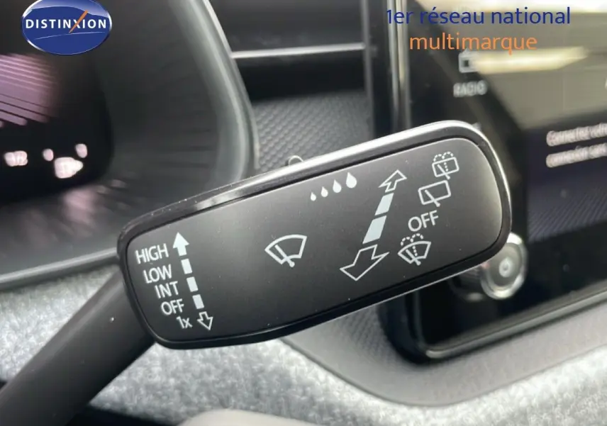 Gros plan sur la manette d'essuie-glace du Skoda Kamiq noir magique métal, avec tableau de bord en arrière-plan flou.