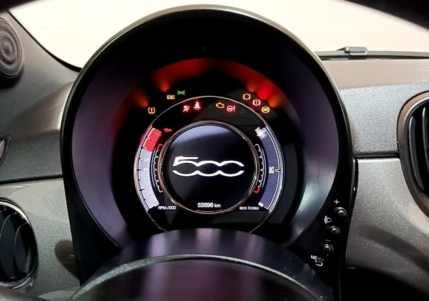 Vue rapprochée du tableau de bord numérique de la Fiat 500 gris foncé, avec affichage multifonctions et voyants allumés.