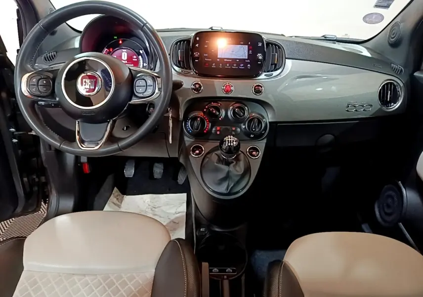 Vue intérieure frontale du tableau de bord gris clair et volant cuir noir de la Fiat 500 Hybrid 2021 avec écran tactile central.
