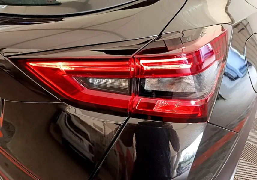Gros plan sur le feu arrière droit rouge d’un Nissan Juke noir 2023, mettant en valeur ses lignes anguleuses et détails lumineux.
